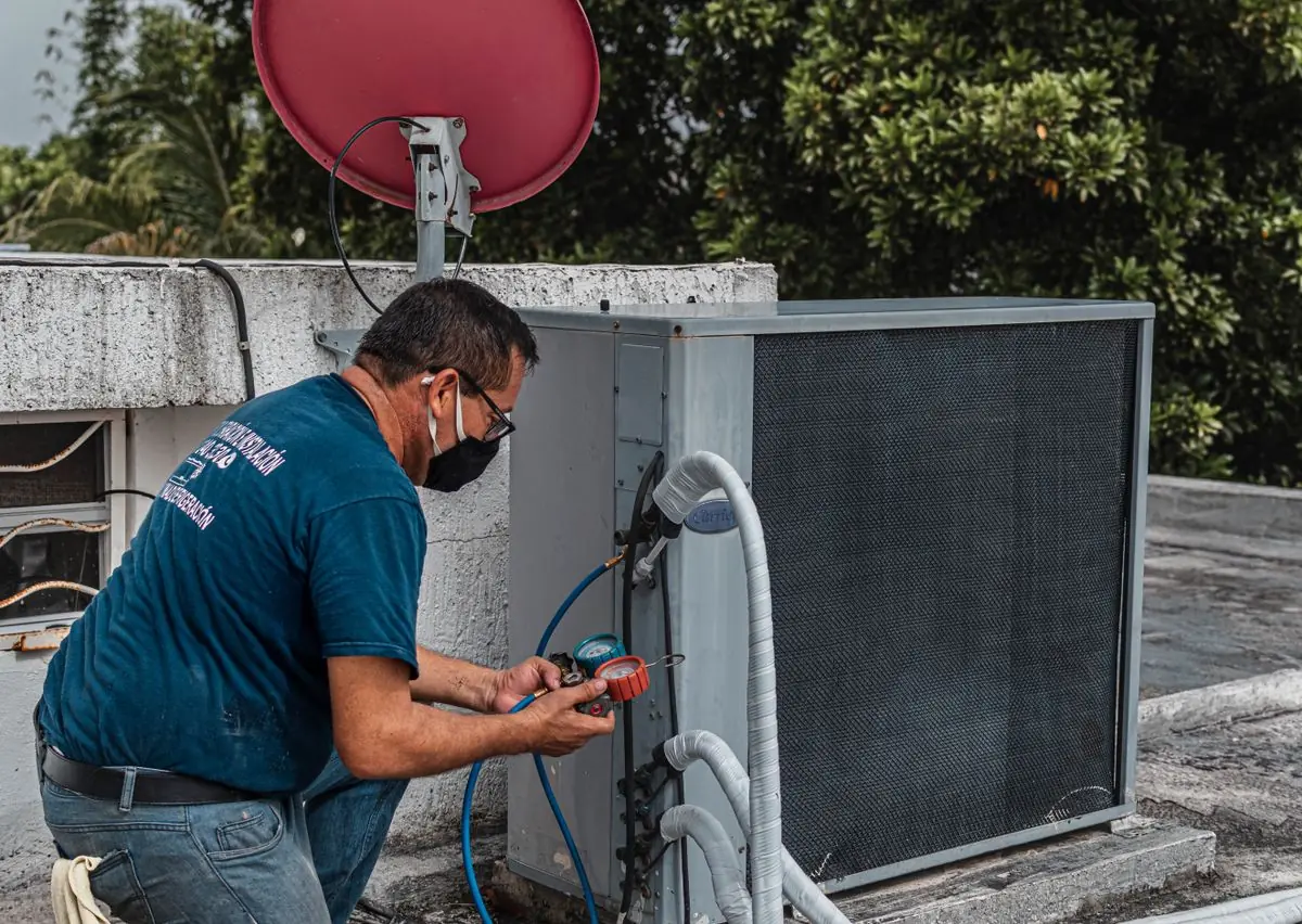 Stock photograph: technician working on an outdoor air-conditioning unit.